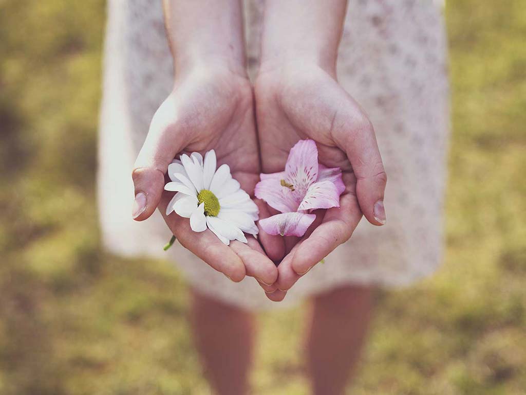 An image of a person holding flowers is symbolic of the sensitivity needed for Detecting Blockages in the Chakras.